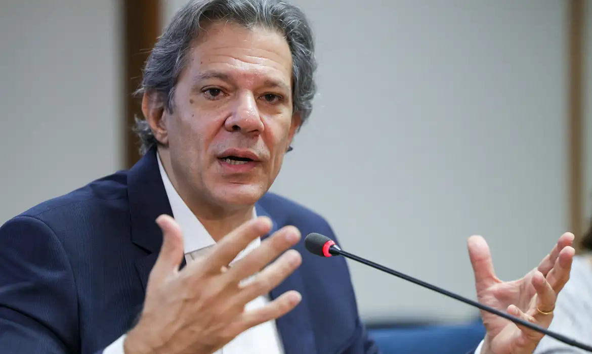 O ministro da Fazenda, Fernando Haddad, disse na manhã de hoje (7) que as políticas que o governo tem tomado para levar o dólar a um “patamar adequado” terão reflexos nas próximas semanas. A afirmação foi feita pelo ministro durante uma entrevista concedida ao programa Manhã Cidade, da Rádio Cidade, de Caruaru (PE). “A política que estamos adotando para trazer esse dólar em um patamar mais adequado também vai ter reflexo nos preços nas próximas semanas”, disse o ministro, durante a entrevista. O ministro não detalhou quais seriam essas ações, mas destacou que a eleição de Donald Trump à presidência dos Estados Unidos fez o dólar se valorizar no mundo todo no ano passado, o que ajudou a pressionar os preços dos alimentos. No entanto, disse o ministro, neste momento, o dólar já começou a perder força. “No final do ano passado, nós tivemos uma ocorrência que foi a eleição do Trump, nos Estados Unidos. E isso fez com que o dólar se valorizasse no mundo inteiro. Agora, se você acompanhar o que está acontecendo, o dólar está perdendo força. Já chegou a R$ 6,30 no ano passado e hoje está na casa dos R$ 5,77. Então, isso também colabora para redução do preço dos alimentos no médio prazo”, destacou. Para o ministro, a safra recorde prevista para este ano também deverá ajudar a reduzir os preços dos alimentos. "A partir de março nós vamos começar a colher essa safra, que vai ser recorde. Nós vamos colher como nunca colhemos. E tem o ciclo do boi também, que está no final. E isso tudo vai ajudar a normalizar essa situação”, disse. Durante a entrevista, o ministro afirmou ainda que a política de valorização do salário mínimo “é uma das formas de garantir que o trabalhador mantenha seu poder de compra” e que isso tem sido uma meta do governo do presidente Luiz Inácio Lula da Silva, após sete anos de congelamento do salário mínimo nos governos de Michel Temer e Jair Bolsonaro. “O salário mínimo ficou congelado por sete anos. Mas desde que o presidente Lula assumiu, há apenas dois anos, o valor que estava R$ 1.100 foi reajustado para R$ 1.518. Obviamente que você não consegue corrigir sete anos de má administração em dois. Mas eu penso que o presidente Lula, com o compromisso que tem com as pessoas que precisam mais do Estado, já começou uma política de valorização do salário mínimo”, destacou Haddad. “Vamos continuar tomando as medidas de aumentar o salário mínimo, corrigir a tabela do Imposto de Renda, melhorar o poder de compra do salário, baixar o dólar e melhorar a safra para combater os preços altos”, reforçou o ministro.